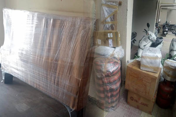 JK Bros Packers and Movers crew wrapping furniture before loading