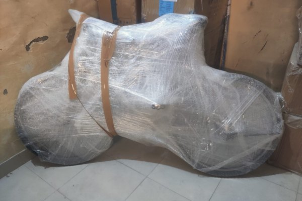 Two-wheeler packed in protective wrap for transport from Bangalore
